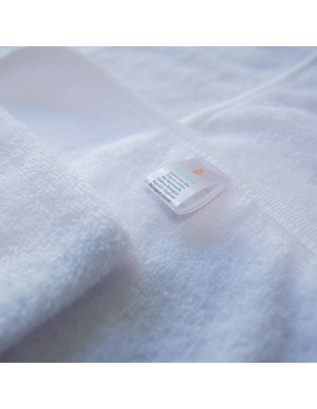 zoom sur la cap de bain et gant blanche avec étiquette en coton bio GOTS
