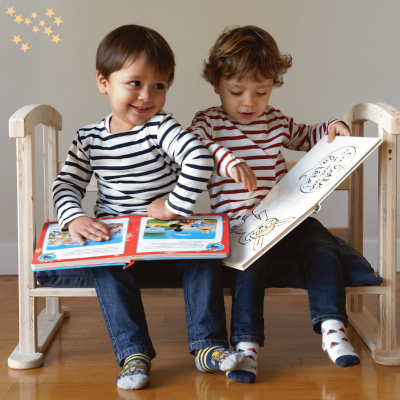 2 enfants assis sur le canapé enfant du berceau évolutif et lisant des livres