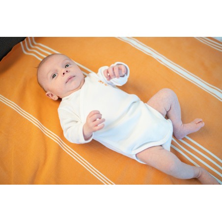 body bébé blanc à forme croisée sur bébé aux poings serrés